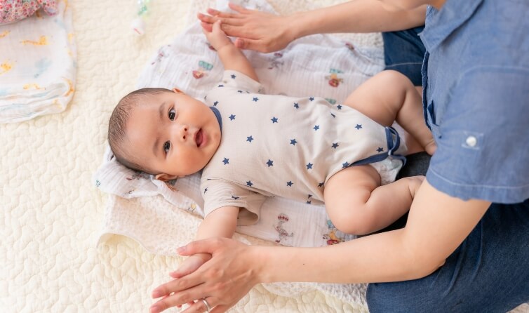 母親と手を合わせてカメラ目線の赤ちゃん
